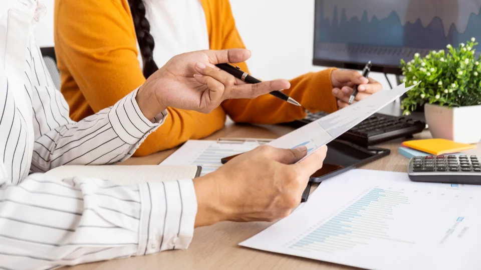 Two people review an employee compensation package together.