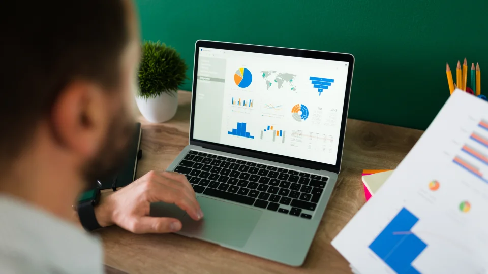 A person looks at compensation data and performance charts on a laptop screen.