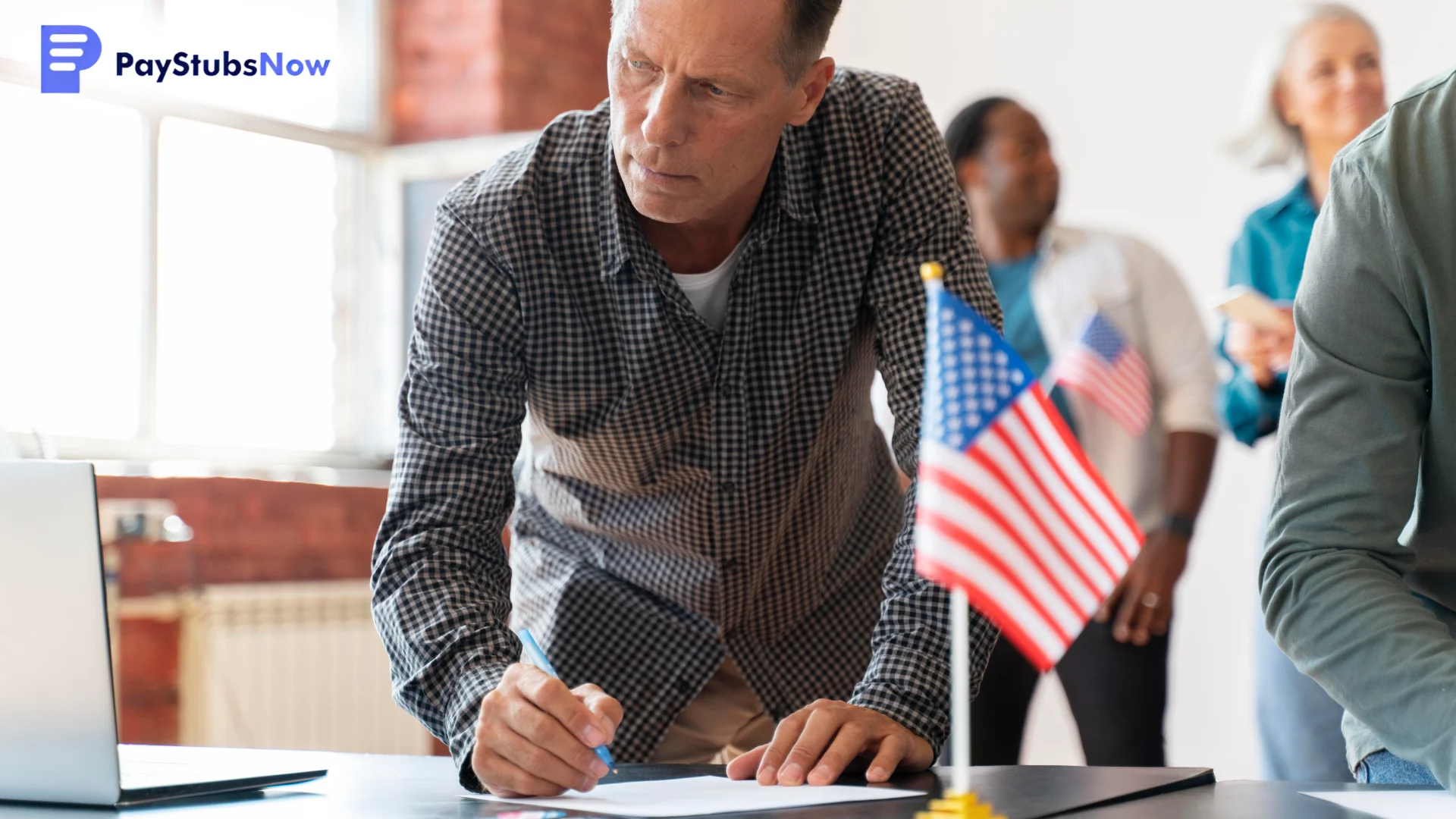 A man filling out paperwork at a desk decorated with American flags