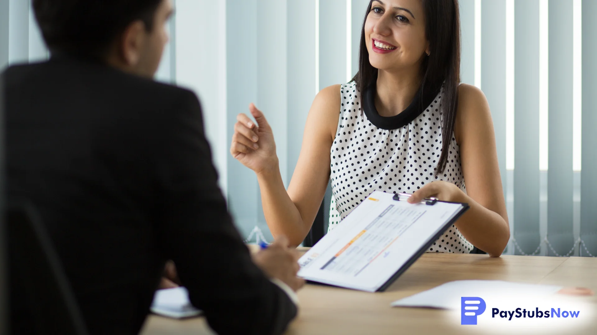 A smiling businessperson holding a clipboard during a meeting