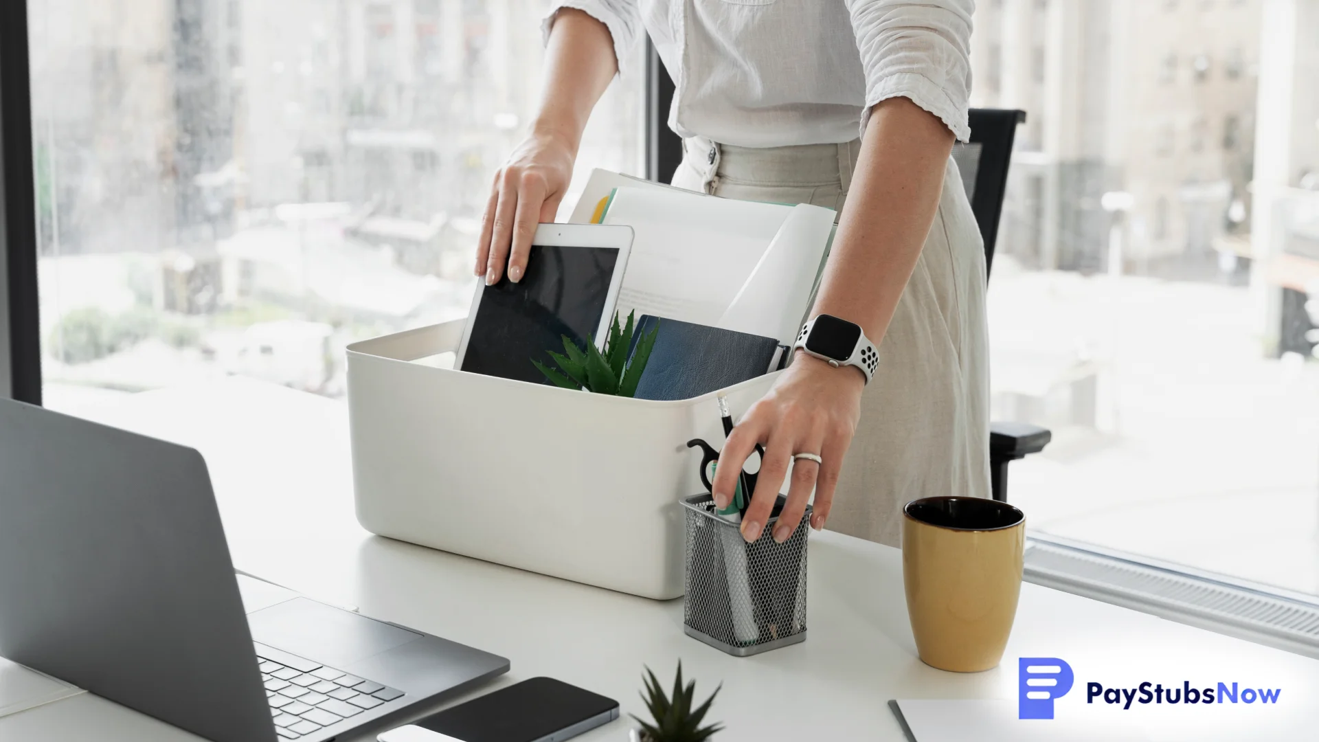 An employee unpacking office items, including a tablet, files, and stationery, from a storage box while preparing the workplace