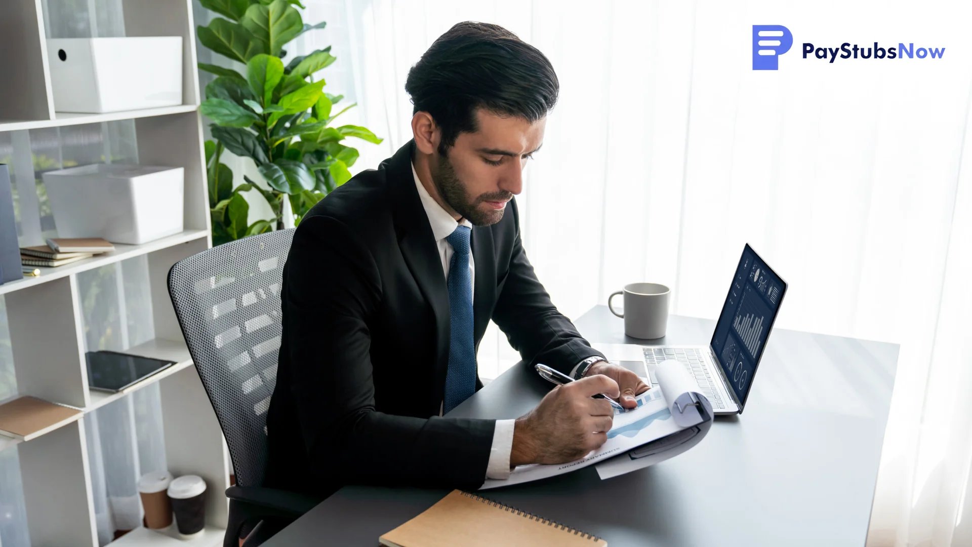 An individual working diligently at a laptop and clipboard.