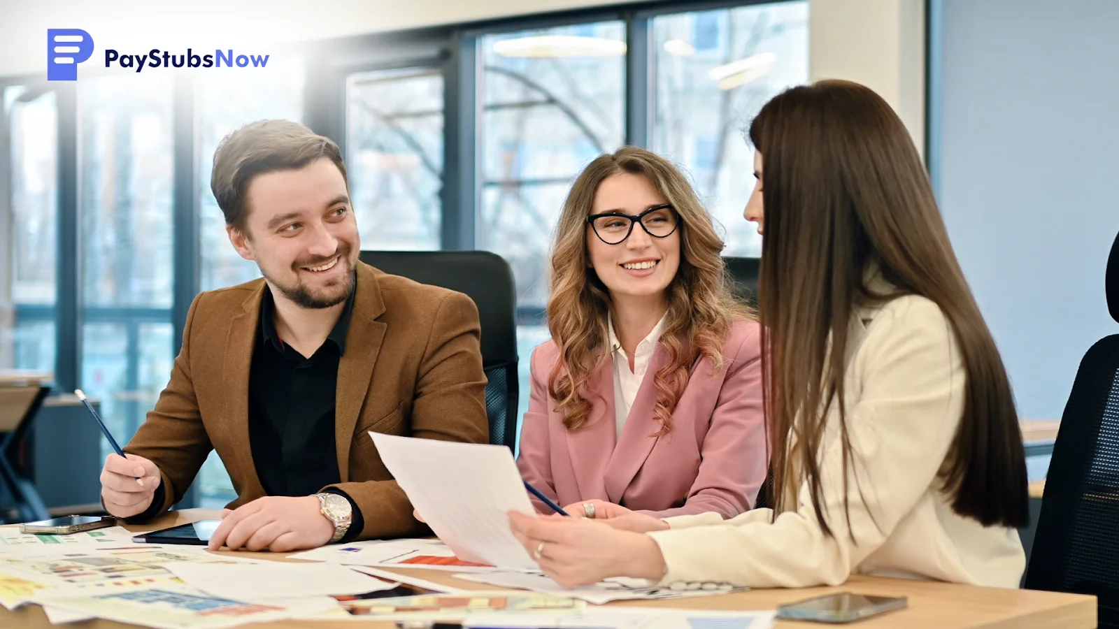 Colleagues smiling while discussing paperwork.